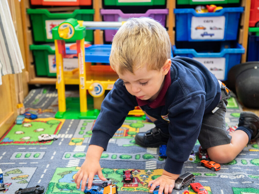 student playing with cars