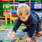 student playing with cars