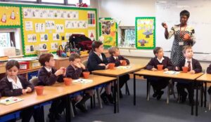 Children listening to their teacher before they make their own plant pots
