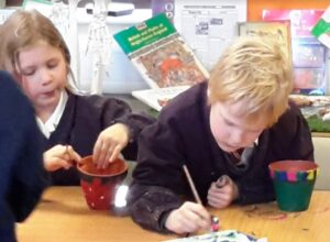 Children painting their plant pots