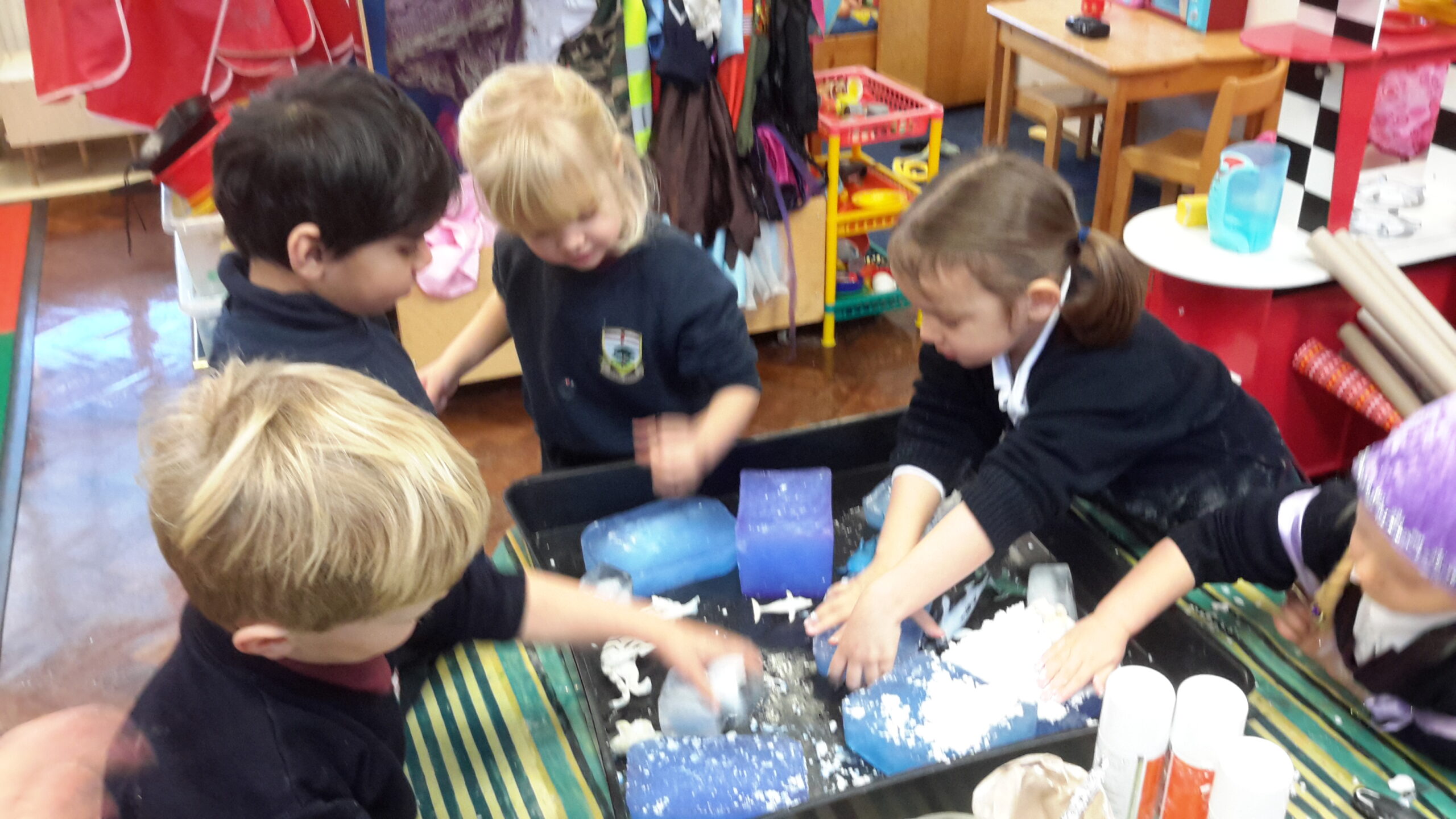Children creating snow by using baking powder and shaving cream